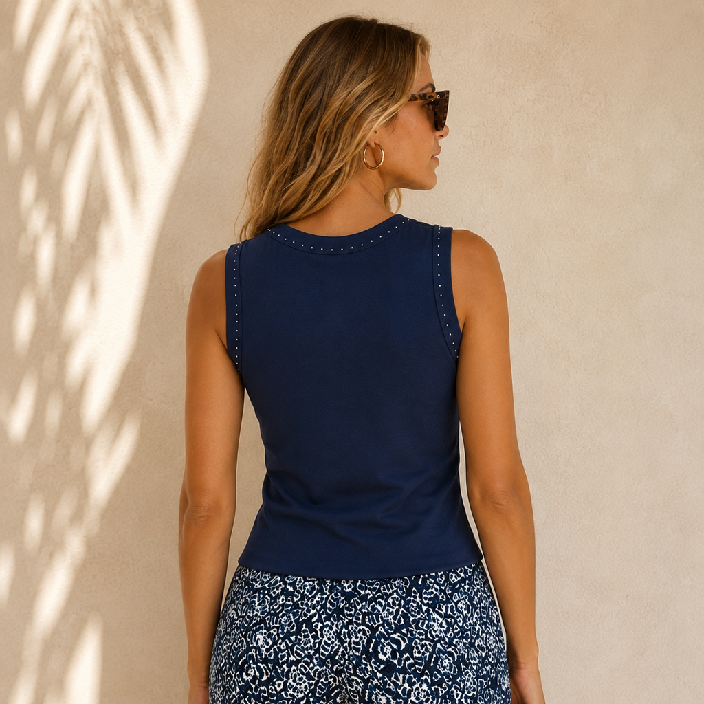 The Nic + Zoe Perfect Rib Knit Studded Tank brings an elevated touch to a timeless everyday essential. Designed in Nic + Zoe’s loved ribbed cotton-modal blend, this tank offers a soft, drapey feel with just the right amount of stretch for all-day comfort.

A higher neckline and subtle yoke seaming create a polished, flattering shape, while placed silver stud accents add a refined hint of shine. Easy to wear on its own or layered under a jacket or cardigan, this versatile knit tank is perfect for dressing up