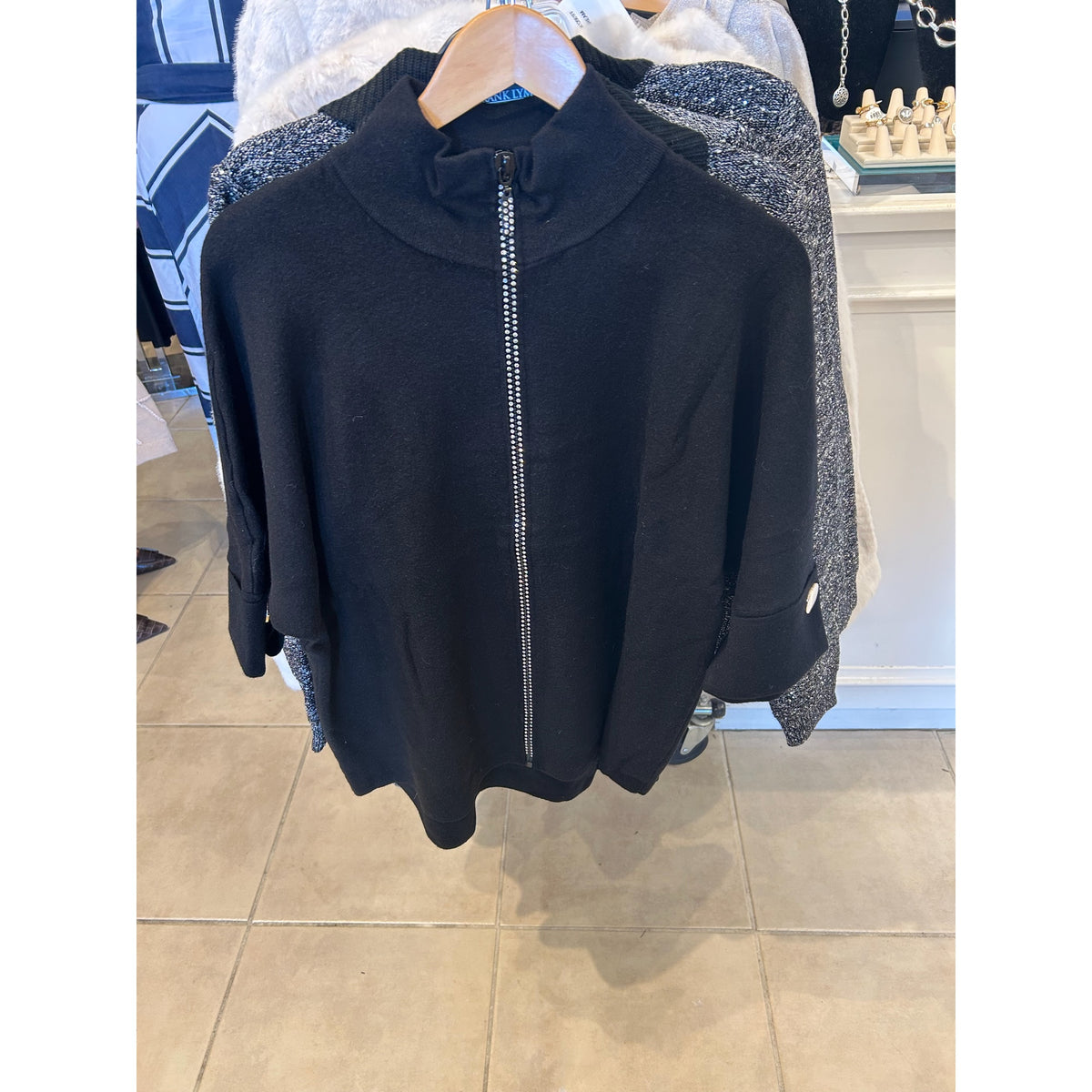 Original front and back photographs of the black Metric Knits style 12579- cardigan with a mock neck, zip front and turn-back cuffs.